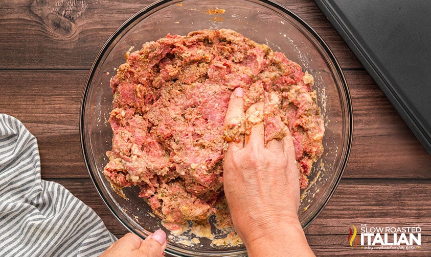 mixing best meatloaf recipe ingredients on a large bowl