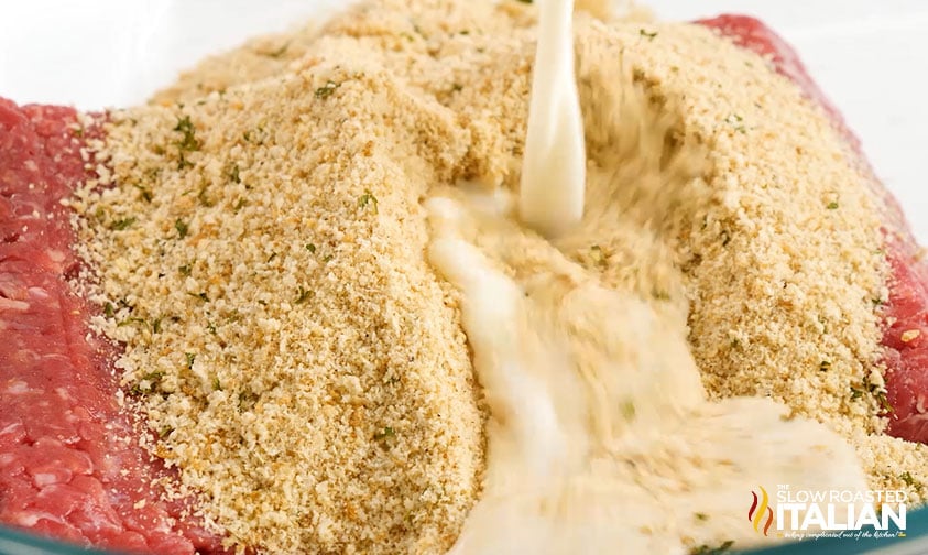 close up: pouring milk over breadcrumbs and ground beef