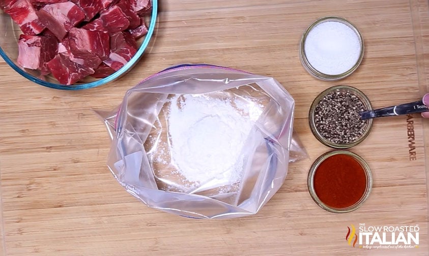 preparing to coat cubed chuck roast in flour and seasonings for beef soup