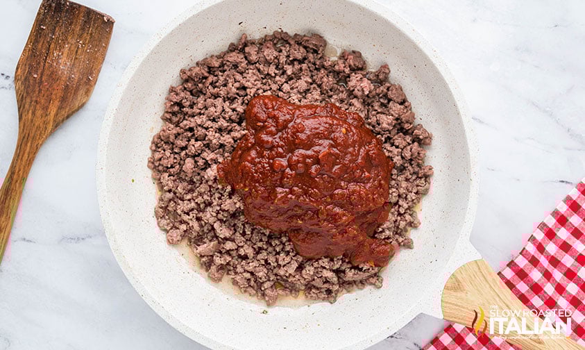 adding sauce to cooked ground beef for easy sloppy joes