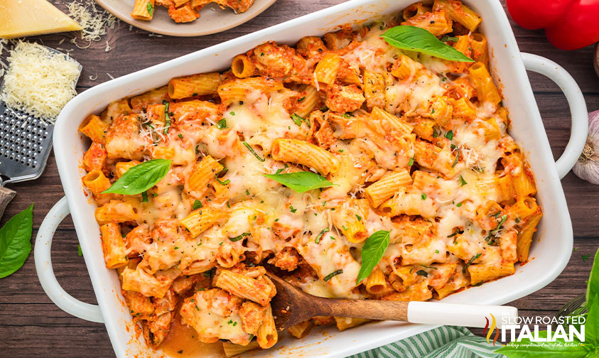 cheesy pasta bake in a baking dish with serving spoon