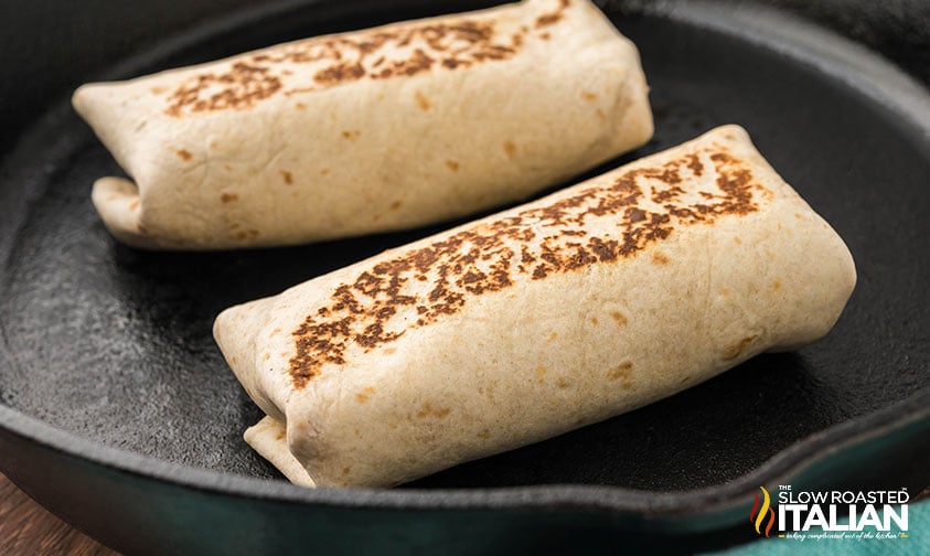 toasted bean and cheese burritos in a cast iron skillet