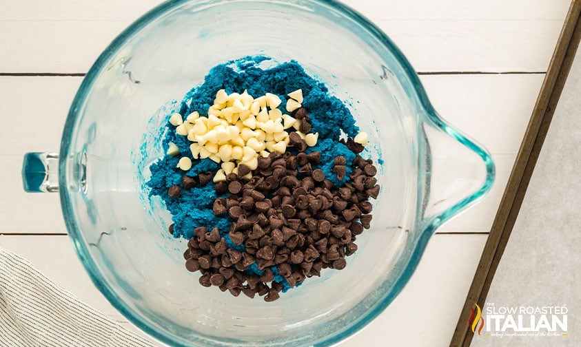 mixing white chocolate chips and chocolate chips in monster cookies dough