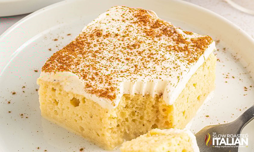 closeup of eggnog tres leches cake on a white plate