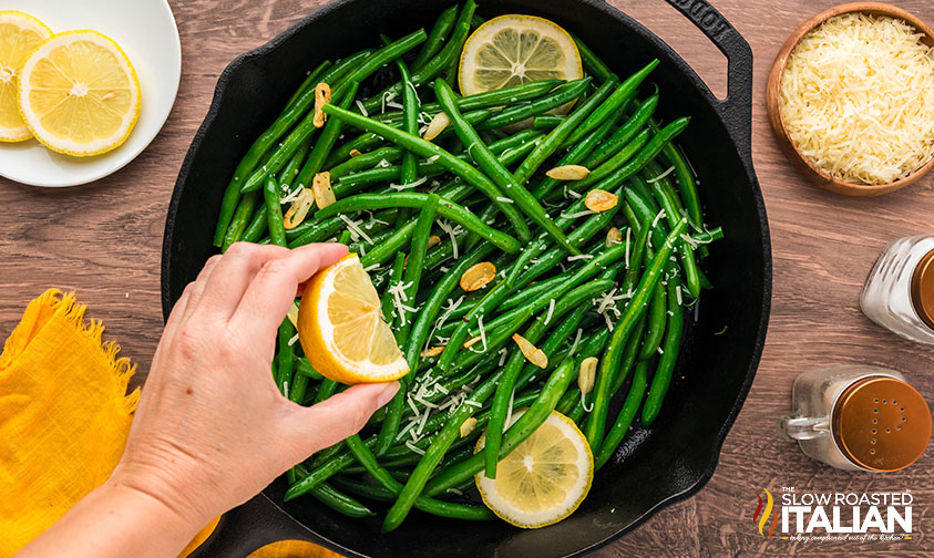 squeezing lemon juice over garlic green beans