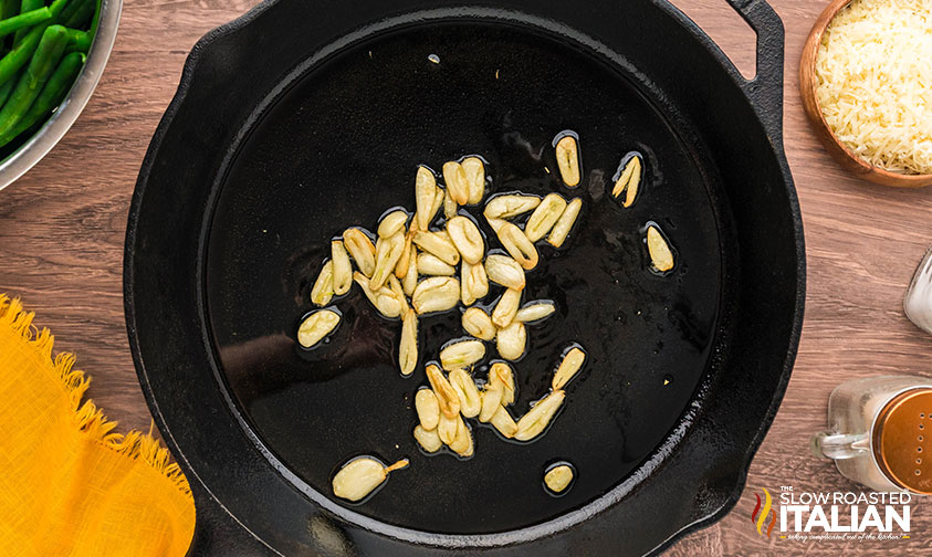 tasting garlic in a skillet for garlic green beans