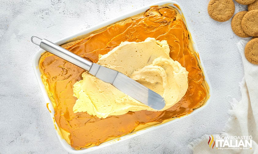 adding dulce de leche and molasses mousse to top of gingerbread layer cake
