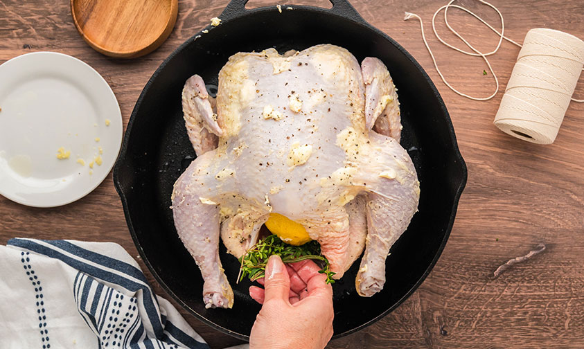 stuffing lemon roasted chicken cavity with rosemary, lemon and garlic