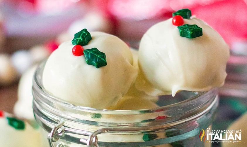 snickerdoodle truffles dipped in white chocolate and decorated with holly berry sprinkles