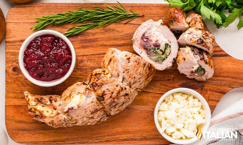 sliced stuffed pork tenderloin on a cutting board
