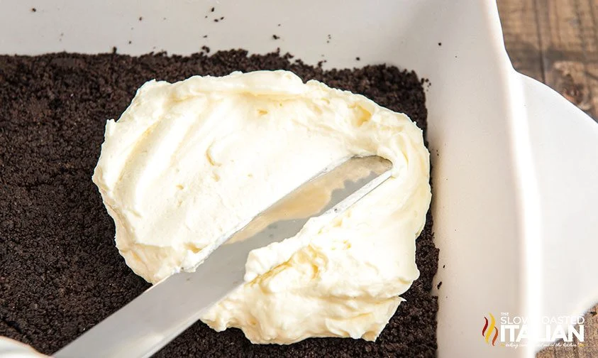 spreading whipped cream cheese layer over Oreo crust