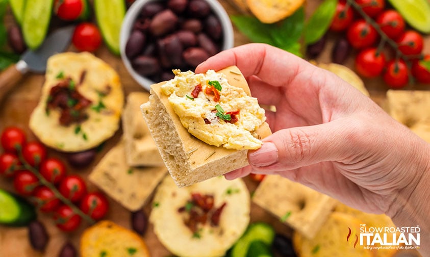 closeup of baked ricotta with sun dried tomatoes on a slice of bread