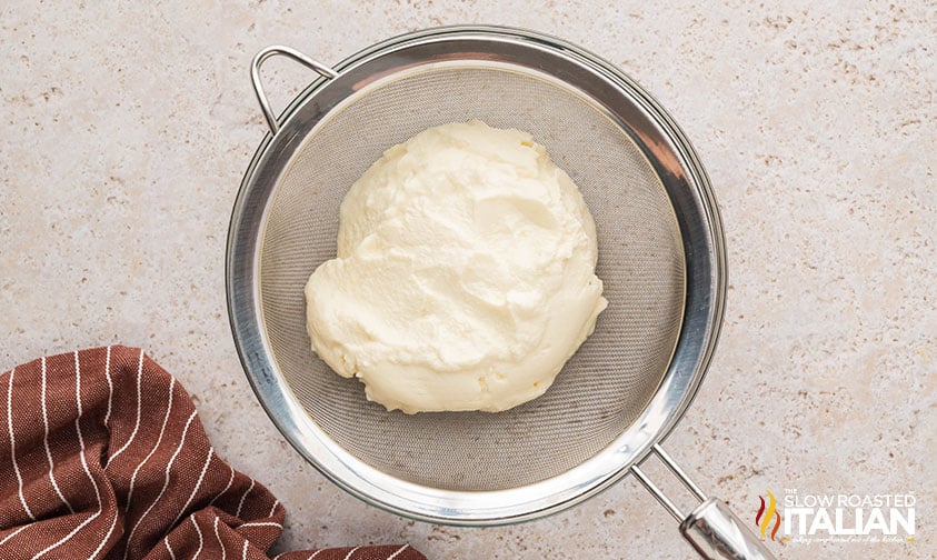 draining ricotta in a small sieve