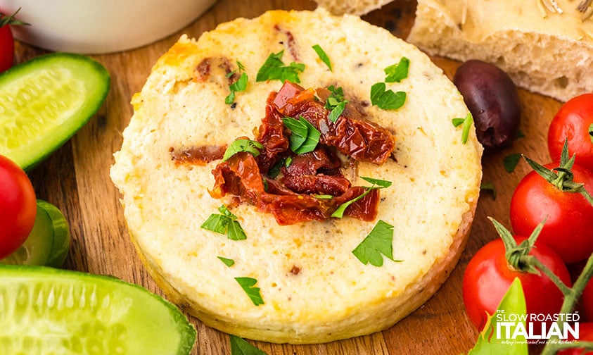baked ricotta with sun dried tomatoes on a serving board