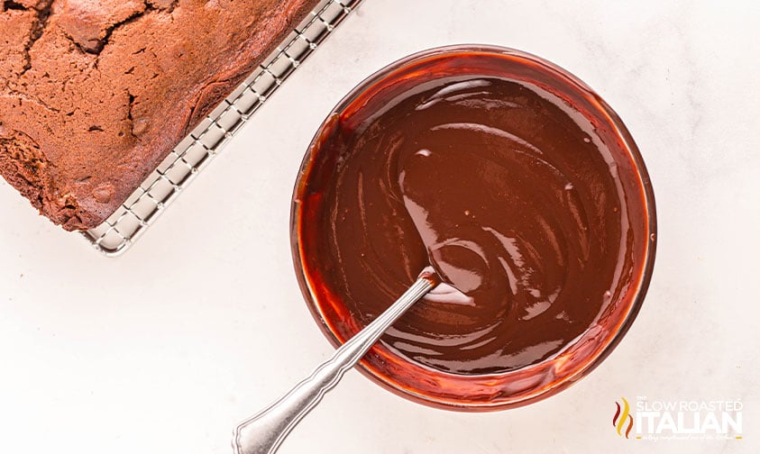 mixed chocolate topping for chocolate pound cake in a small mixing bowl with spoon