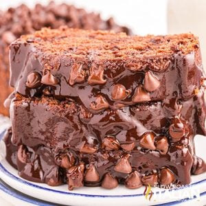 closeup of sliced and stacked chocolate pound cake covered with chocolate topping and chocolate chips