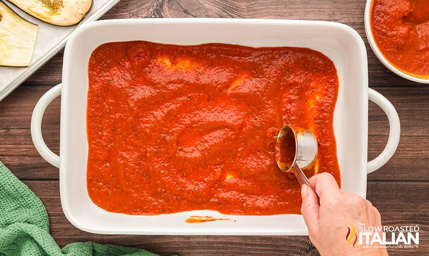 spreading marinara in bottom of 9x13 baking dish