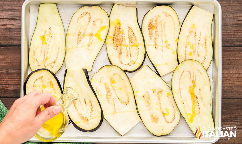 drizzling sliced eggplant with olive oil before baking