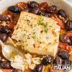 closeup of baked feta with tomatoes and olives