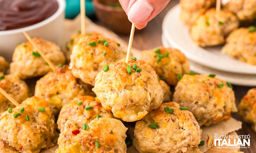 closeup of stacked sausage poppers on a wooden serving boartd