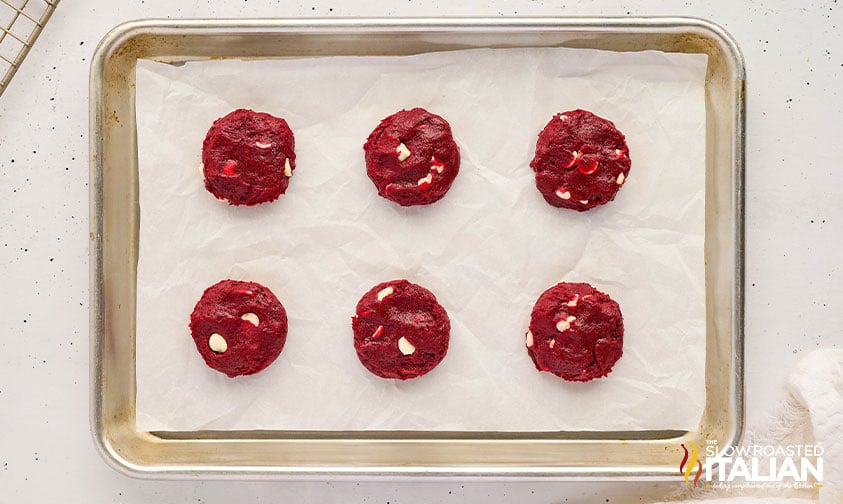 balls of red velvet cake mix cookies dough on a baking sheet