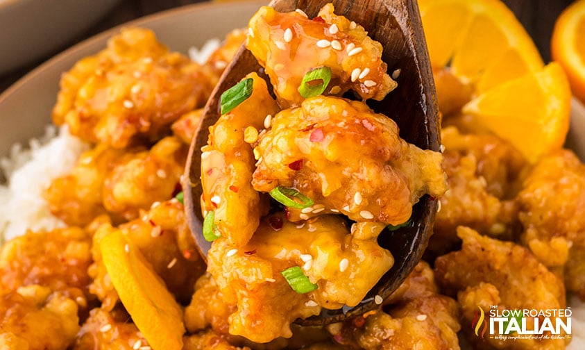 closeup of simple orange chicken sprinkled with sesame seeds and green onion