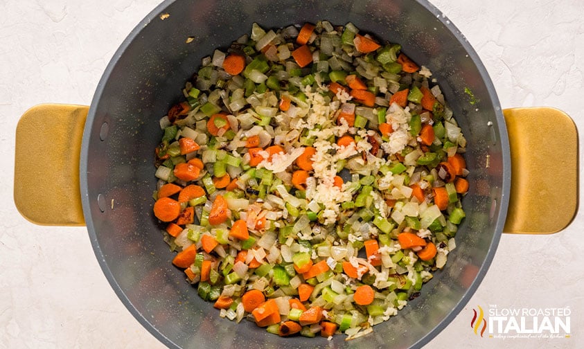 adding diced garlic to vegetables for split pea and ham soup