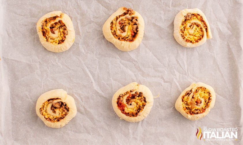 rolled taco pinwheels on a parchment lined baking sheet