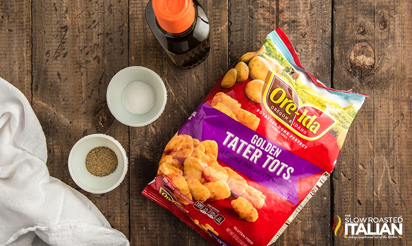 bag of Ore-Ida Golden Tater Tots next to bowls of salt and pepper and a bottle of oil