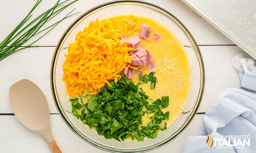 diced ham, shredded cheese, and chopped spinach in bowl with egg mixture