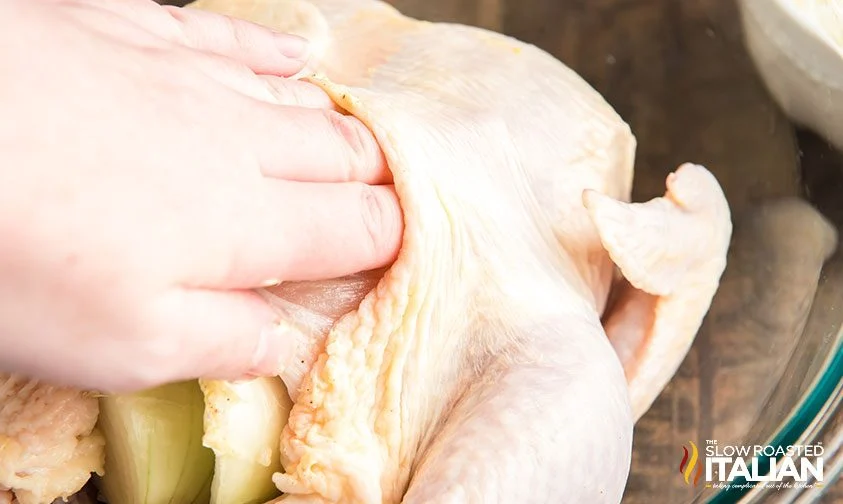 rubbing garlic butter under the skin of whole chicken