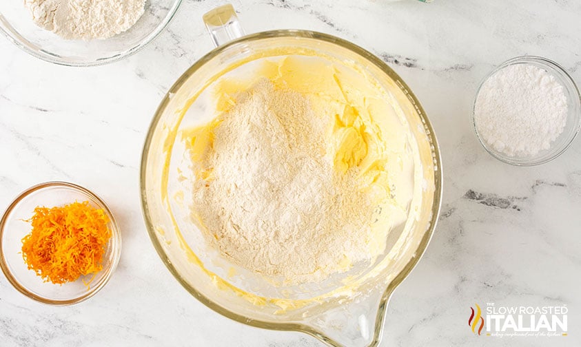 adding dry ingredients to batter for orange pound cake