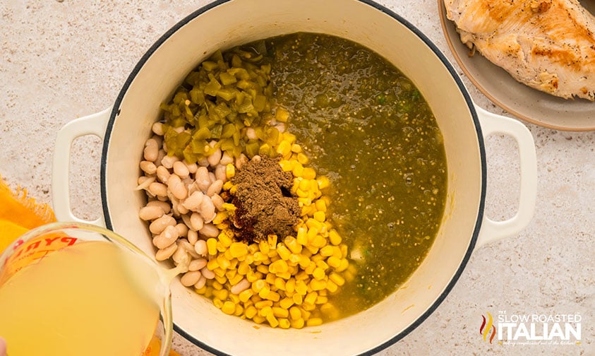 adding salsa verde soup ingredients to a large pot