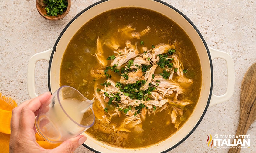 adding shredded chicken to salsa verde chicken soup