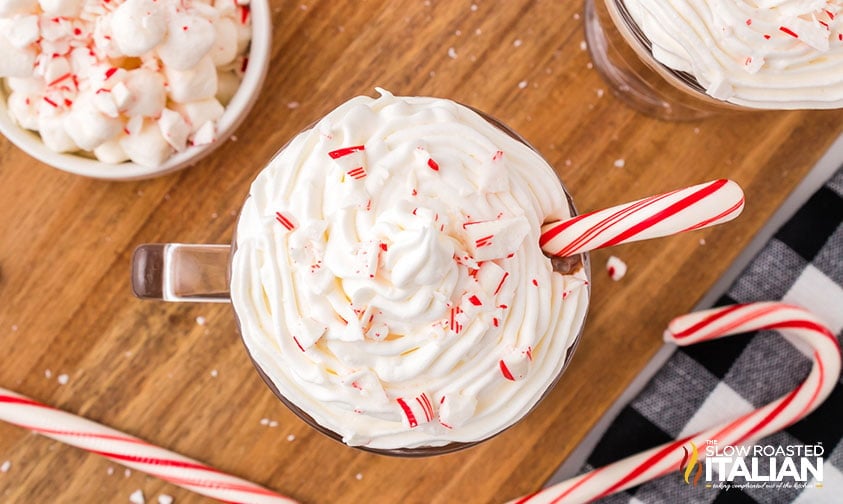 overhead: copycat peppermint mocha topped with whipped cream, candy pieces, and a peppermint stick