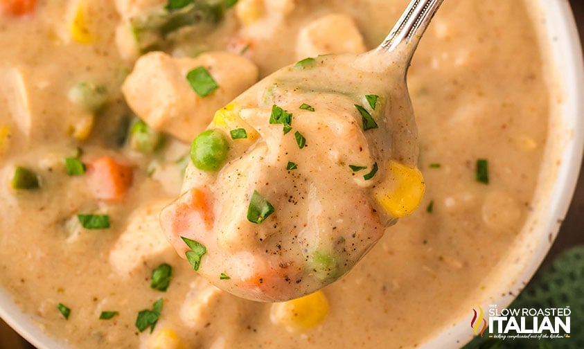 closeup of a spoon full of creamy chicken pot pie soup