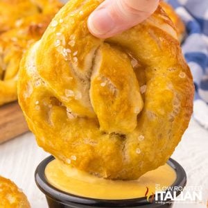 closeup of soft pretzels dipped in cheese sauce