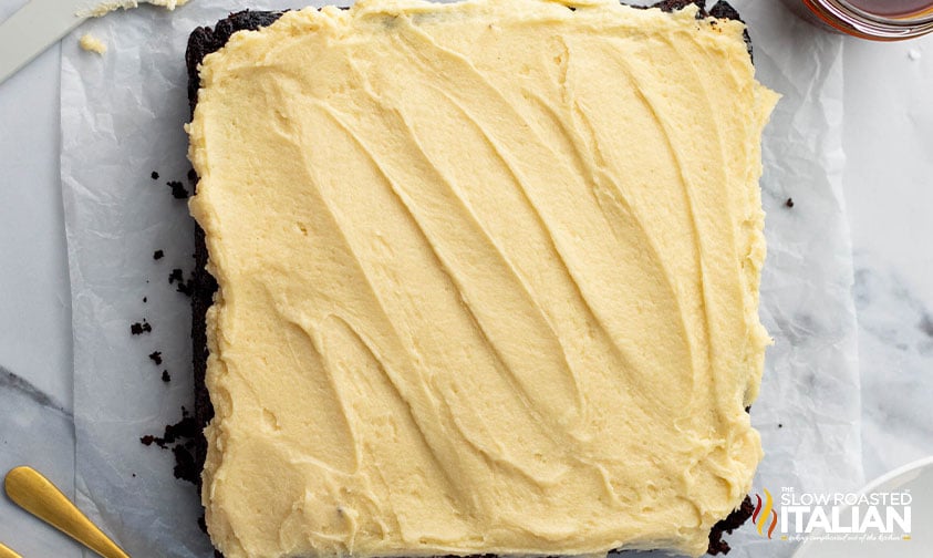 adding frosting to guinness chocolate cake