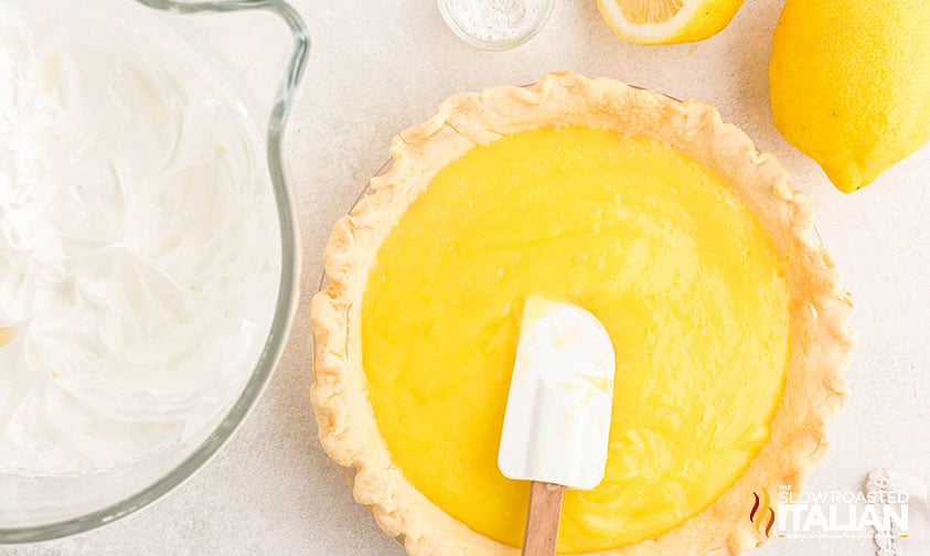 lemon meringue pie filling poured in a pie crust