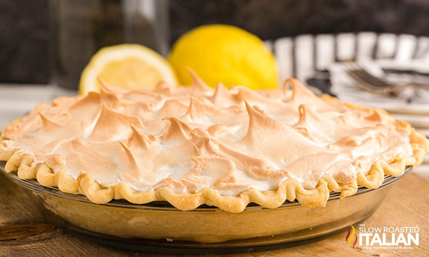 baked lemon meringue pie on the table with fresh lemons