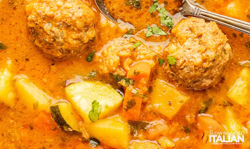 closeup of albondigas soup in a bowl with spoon