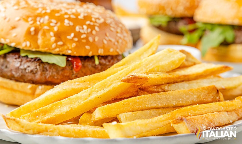 beef tallow french fries on a plate with a big juicy burger