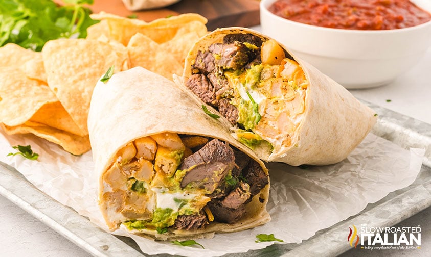 sliced california burrito on a serving tray with tortilla chips