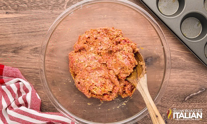 meatloaf cups mixture in a large bowl with a wooden spoon