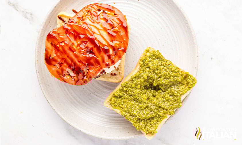 sliced tomatoes and pesto added to chicken caprese sandwich