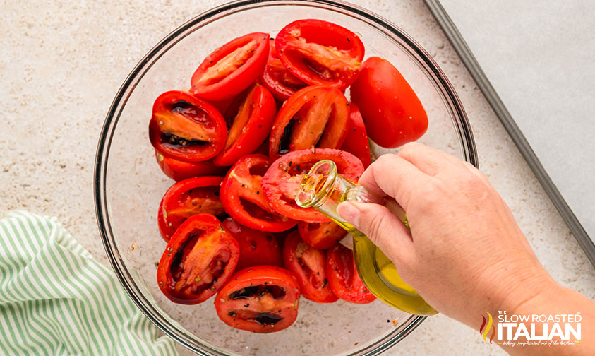 adding seasoning and oil to sliced tomatoes for caprese salad recipe
