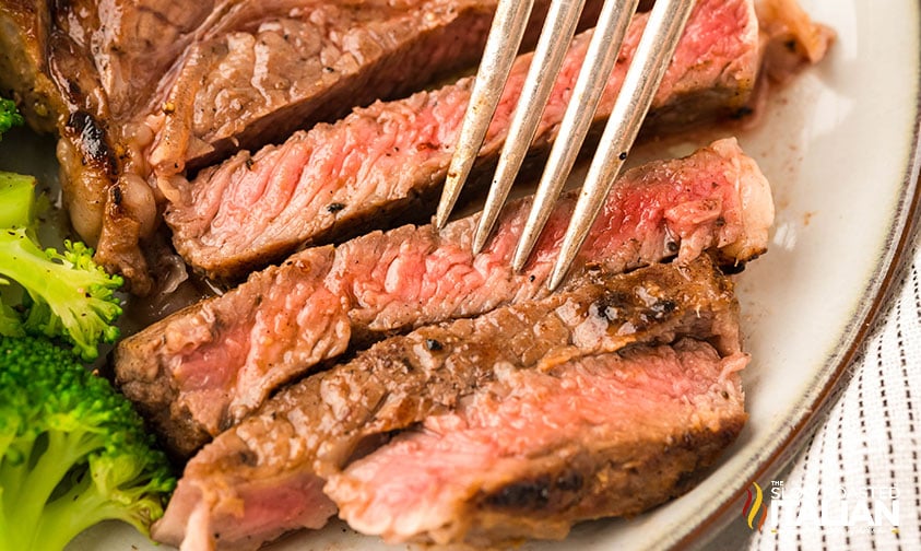 picking up a slice of boneless steak recipe with a fork