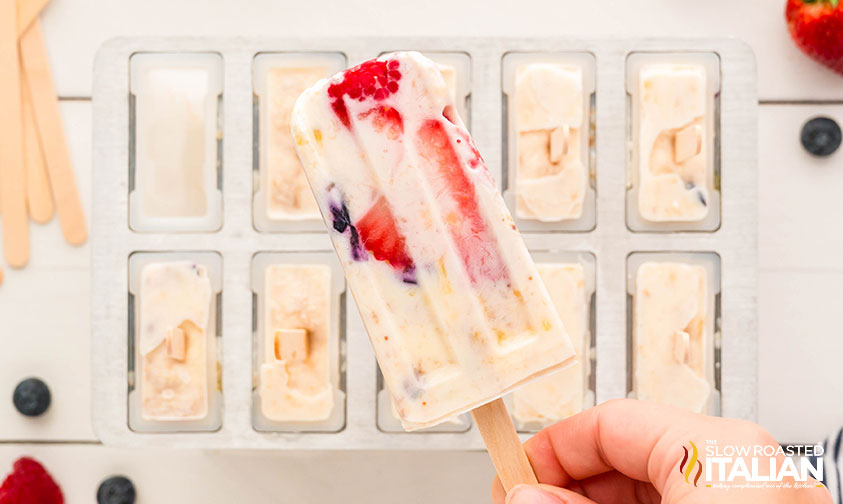 hand holding banana berry popsicles