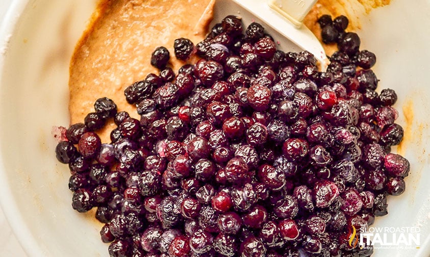 adding blueberries to blueberry fritters batter