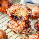 closeup of stacked blueberry fritters on a cooling rack